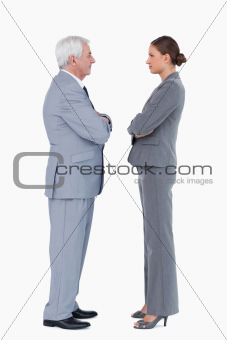 Businesspartner standing face to face with arms folded