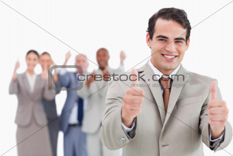 Salesman with team behind him giving thumbs up