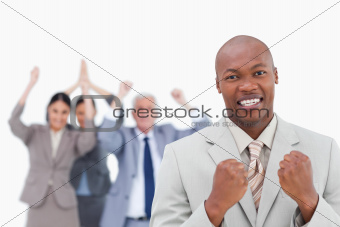 Successful businessman with cheering team behind him