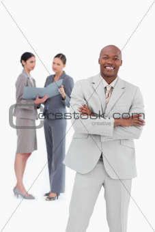 Smiling businessman with co-workers behind him