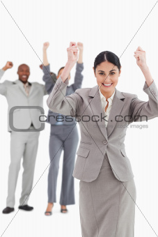 Triumphant saleswoman with cheering associates behind her