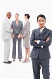 Confident saleswoman with negotiating trading partners behind her