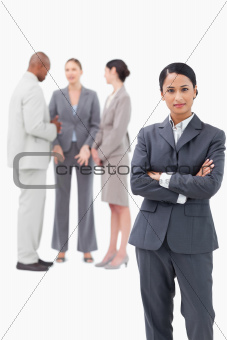 Confident saleswoman with negotiating trading partners behind her