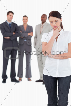 Thinking businesswoman with three colleagues behind her
