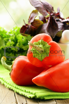 Fresh ripe red bell peppers on a kitchen board