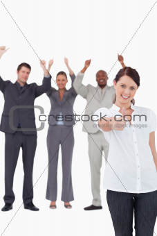 Businesswoman with cheering colleagues behind her giving approval