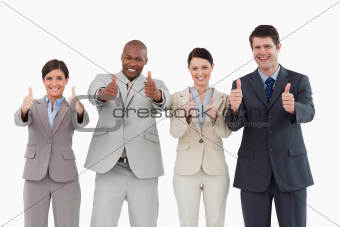 Smiling salesteam giving thumbs up