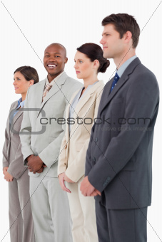 Smiling businessman standing between his colleagues