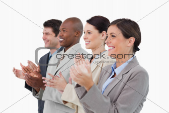 Side view of clapping salesteam standing together