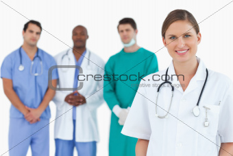 Female doctor with colleagues behind her