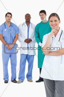 Smiling doctor with male staff members behind her
