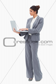 Businesswoman using laptop while standing
