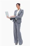 Smiling businesswoman using laptop while standing