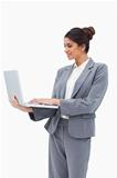 Smiling businesswoman using her laptop while standing