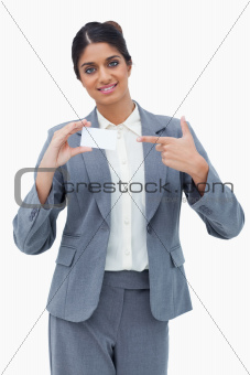 Saleswoman pointing at blank business card