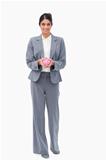 Smiling bank employee with piggy bank in her hands