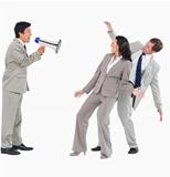 Businessman with megaphone shouting at colleagues