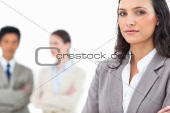 Confident businesswoman with colleagues behind her