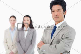 Confident businessman with employees behind him