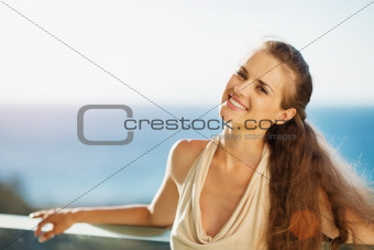 Smiling woman on vacation standing on balcony