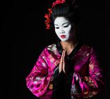 Portrait of geisha with hands together respect gesture isolated on black