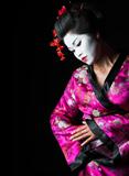 Closeup portrait of geisha isolated on black