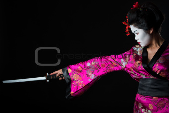Portrait of geisha warrior with sword isolated on black
