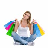 Full length portrait of smiling teenage girl sitting with shopping bags