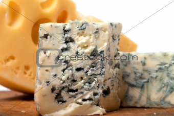 Dorblu and other cheeses on wooden kitchen board