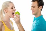 Young guy making her girlfriend eat an apple