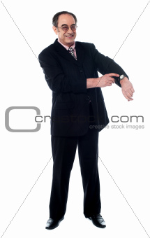Senior businessman pointing towards wrist watch