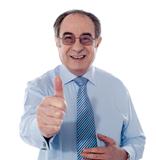 Smiling mature businessman showing thumbs-up