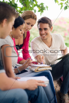 college students doing homeworks in park