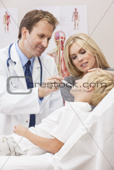 Male Doctor Examining Boy Child With Mother