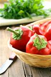 Fresh ripe red bell peppers  in a wicker basket