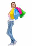 Smiling teenage girl with shopping bags looking on copy space