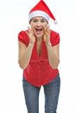 Young woman in Christmas hat shouting through megaphone shaped hands