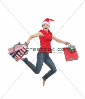Happy woman in Christmas hat with shopping bags jumping