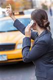 Young Woman on Cell Phone Hailing a Yellow Taxi Cab