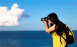Young woman taking photo with cloud background