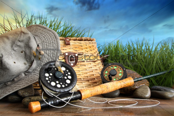 Fly fishing equipment with hat on wooden dock