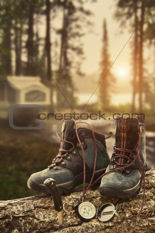 Hiking boots with compass at campsite