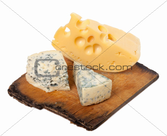 Various types of cheese on old wooden kitchen board