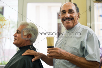 Portrait of senior man working as barber in hair salon