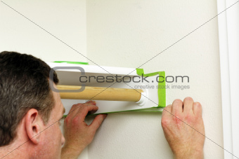 Man Applying Green Painter\'s Tape