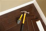 Hammer, Laminate Flooring and New Baseboard Molding Abstract.
