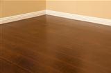 Beautiful Newly Installed Brown Laminate Flooring and Baseboards in Home.