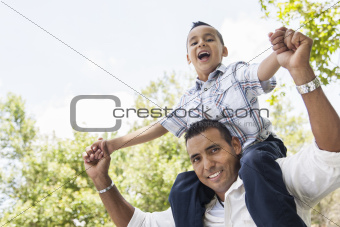 Hispanic Father and Son Having Fun Together Riding on Dad's Back in the Park.