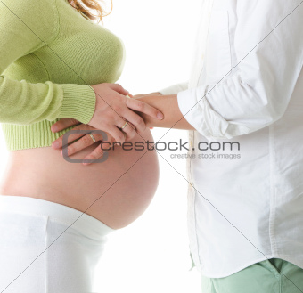 Mom and Dad with hands on the baby