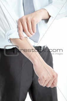 Businessman rolling his sleeves up 